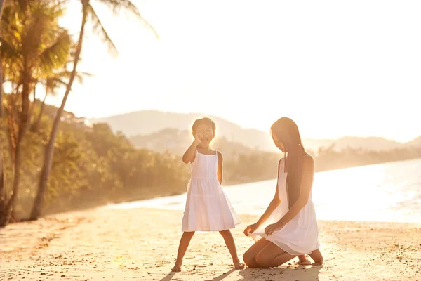 Mutter und Tochter am Strand bei Sonnenuntergang glücklich — Stockfoto