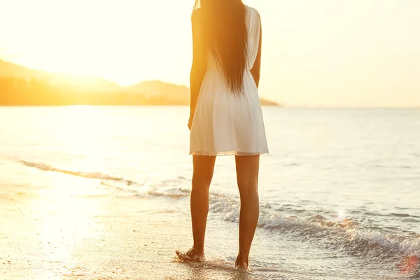 Όμορφη κοπέλα με τα πόδια στην παραλία στο ηλιοβασίλεμα, έννοια της ελευθερίας — Φωτογραφία Αρχείου