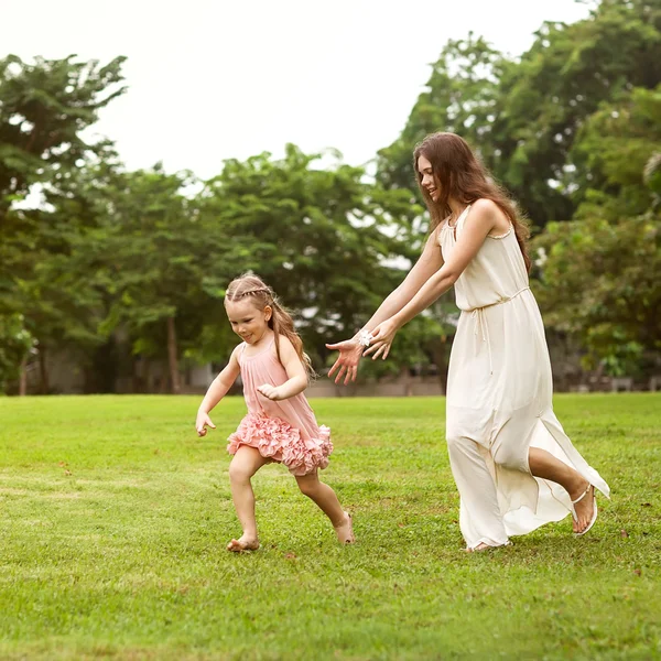 Mor och dotter promenader i parken håller hand i kärlek — Stockfoto