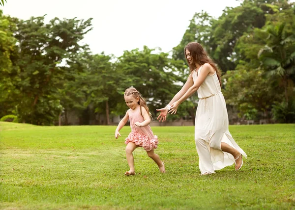 Moeder en dochter wandelen in het park hand in hand in de liefde — Stockfoto