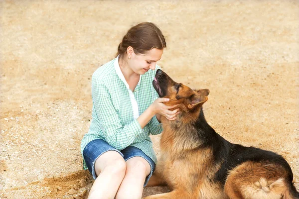 Flicka med hund glad i beach — Stockfoto