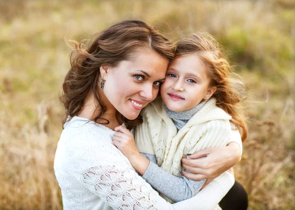 Mother and daughter hugging in love playing in the park — Stock Photo, Image