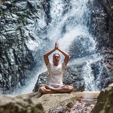 bir şelale Yoga dağlarda nişanlı bir genç adam