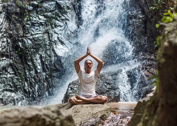 Een jonge man verloofd met een waterval in de bergen van yoga — Stockfoto