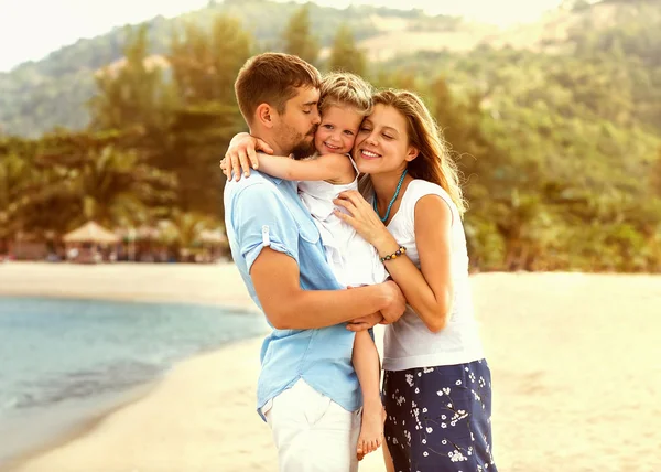 Familia feliz caminando sobre el mar en la playa — Foto de Stock