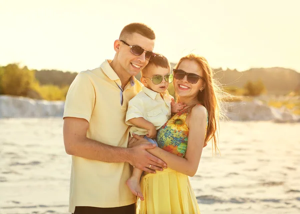 Feliz hermosa familia en la puesta de sol de la playa —  Fotos de Stock