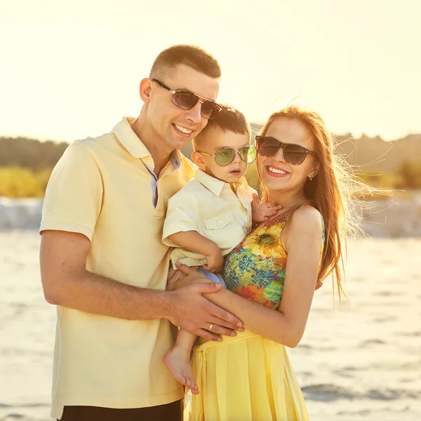 Glada vackra familjen på stranden solnedgången — Stockfoto