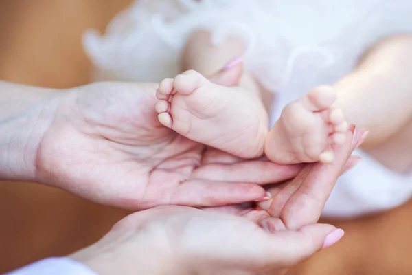 Dziecięca stopa w rękach matki — Zdjęcie stockowe