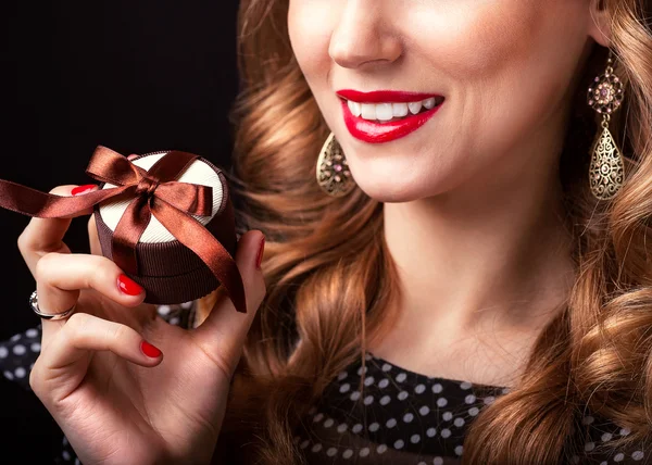 Schöne rothaarige Mädchen mit einem Geschenk in der Hand zum Valentinstag — Stockfoto