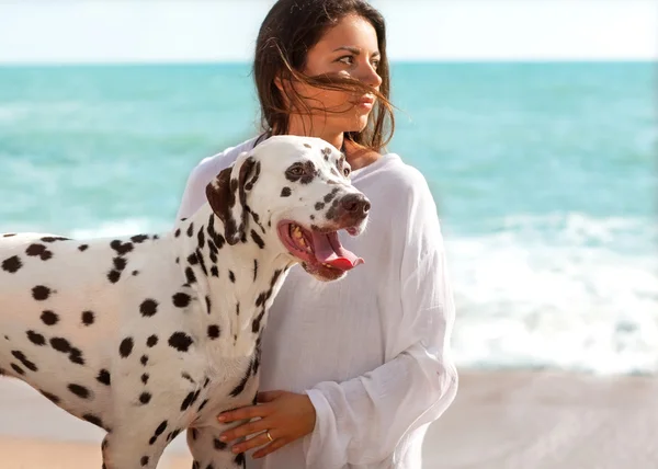 Ragazza in mare con il cane dalmata — Foto Stock
