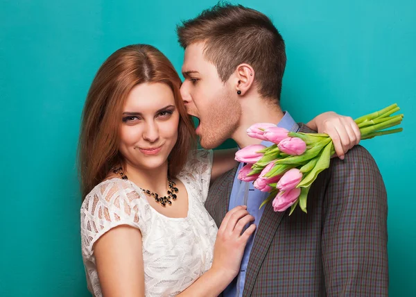 Pareja joven enamorada hacer un corazón y las manos están sosteniendo un ramo — Foto de Stock