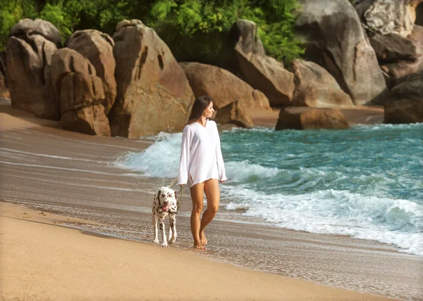 Ragazza in mare con il cane dalmata — Foto Stock