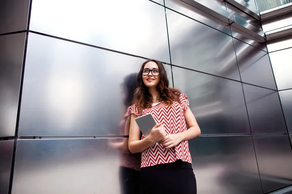 Chica de moda sosteniendo una tableta PC en el fondo del negocio — Foto de Stock