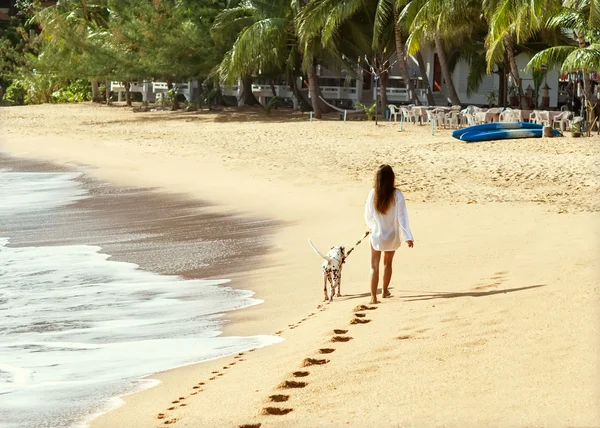 Ragazza passeggiata sulla spiaggia con il cane Dalmazia — Foto Stock