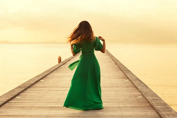 Tyttö kävelee sillalla, käsite vapauden auringonlaskun — kuvapankkivalokuva