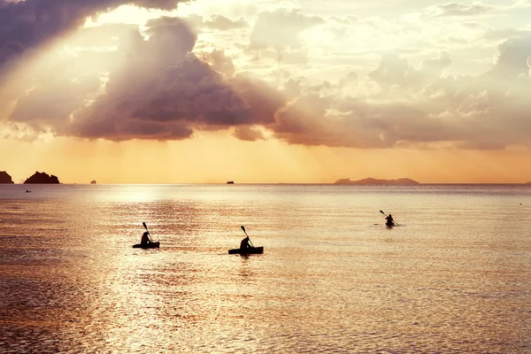 Drei Kajaks schwimmen bei Sonnenuntergang — Stockfoto