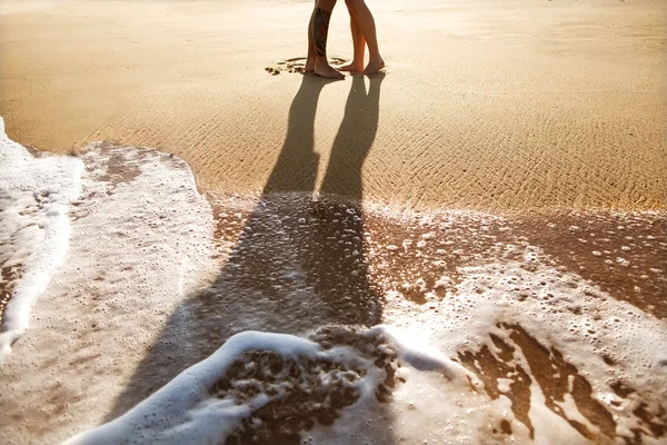 Pareja enamorada de pie sobre la arena junto al mar, puesta de sol —  Fotos de Stock