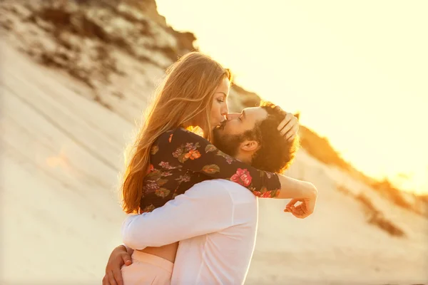 Pareja enamorada en el mar jugando felizmente al atardecer — Foto de Stock