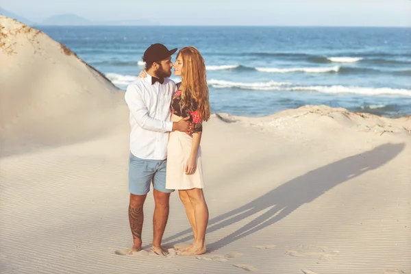 Casal feliz no amor de pé na areia junto ao mar — Fotografia de Stock