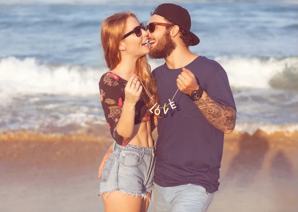 Pareja joven enamorada caminando por el parque tomados de la mano mirando i — Foto de Stock