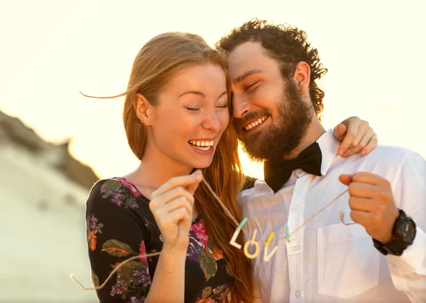 Casal apaixonado no mar jogando feliz ao pôr do sol — Fotografia de Stock