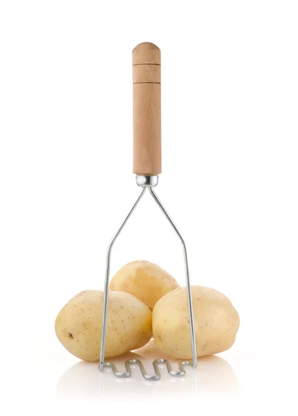 Aardappelen met een aardappelstamper op wit — Stockfoto