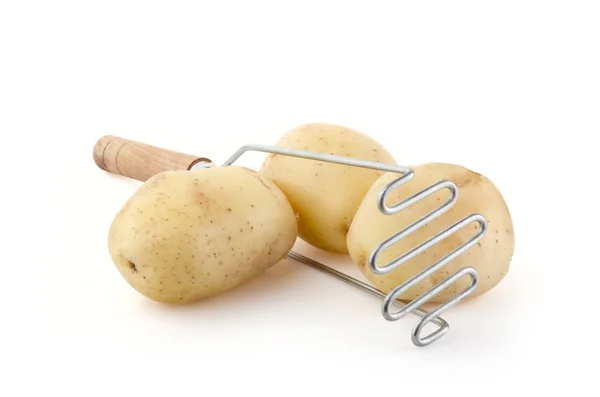 Batatas com Masher de batata em branco — Fotografia de Stock