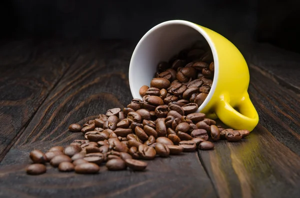 Kávová zrna v žluté Cup — Stock fotografie