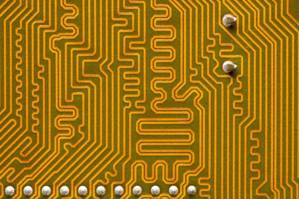 Gros plan d'un circuit imprimé jaune. Le revers de la carte mère d'un ordinateur personnel. Contexte pour l'électronique — Photo