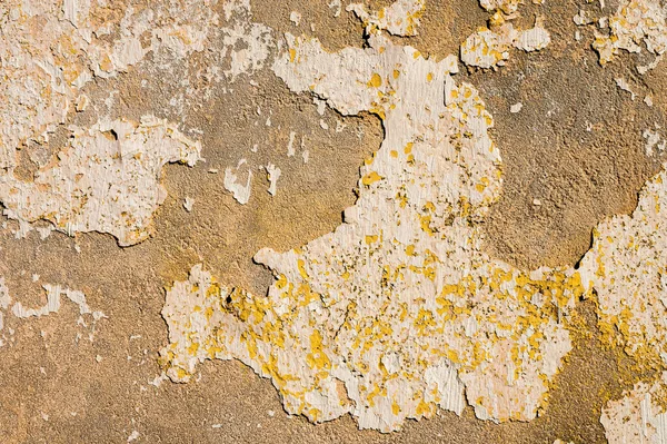 Paredes de cimento envelhecidas com tinta branca azul amarela descascando revestimentos ao ar livre em um fundo pobre. Vindima — Fotografia de Stock