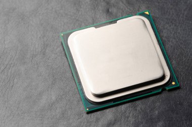 Bir bilgisayar veya dizüstü bilgisayarın işlemci işlemcisi koyu bir mat yüzeyinde yatar. Yakın plan. Elektronik ve bilgisayar ekipmanları. Makro