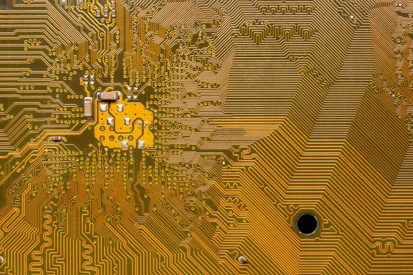 Close-up van een gele printplaat. De achterkant van het moederbord van een personal computer. Achtergrond voor elektronica — Stockfoto