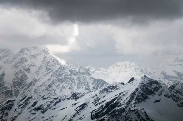 Akşamları Kafkas yüksek dağlarının karla kaplı zirveleri. Dramatik gökyüzü — Stok fotoğraf