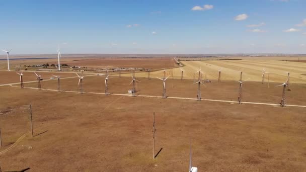 Veduta aerea delle turbine eoliche che generano energia eolica pulita tra i campi gialli. Produzione di energia rinnovabile nelle regioni delle steppe eoliche. — Video Stock