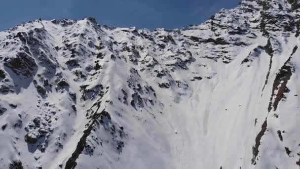 Légi kilátás hófödte meredek lejtők. Keskeny kupon extrém freeride és backcountry síelés magas a hegyekben — Stock videók