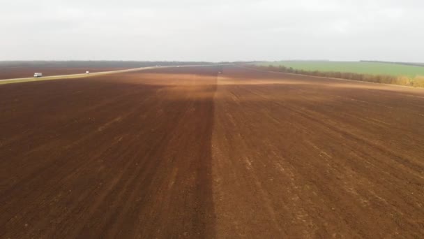 Трактор просочує поле для посіву пшениці. Агроіндустрія. Повітряний вид на роботу в полі. — стокове відео