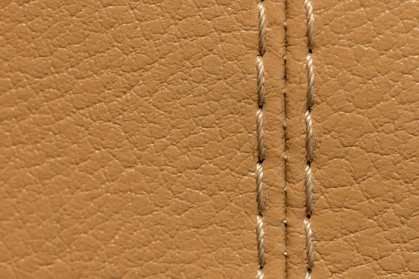 Artificial leather car upholstery, color beige, close-up stitching in macro mode — Stock Photo, Image