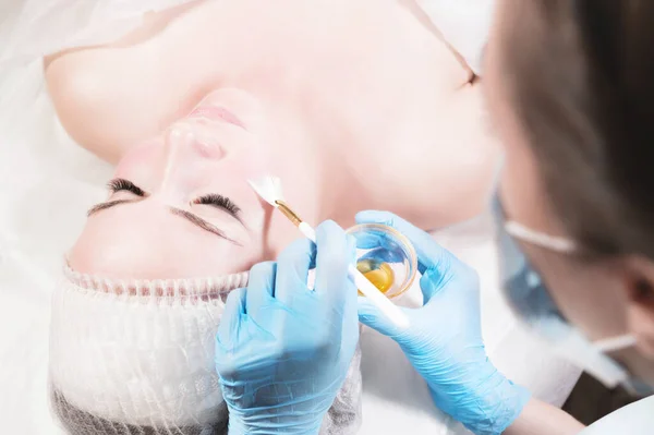 Kosmetikerin in einem Schönheitssalon setzt der Kundin eine Schutzmaske auf. Gesichtspflege und Schönheitsbehandlungen — Stockfoto