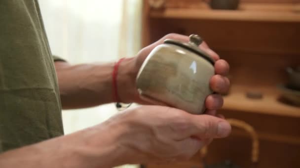 Een mannelijke pottenbakker toont zijn werk Yixing klei theepot voor een handgemaakte theeceremonie in de buurt. Ondiepe scherptediepte — Stockvideo