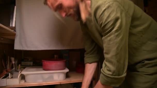 Man pottenbakker kneden klei verslaat het voor installatie op een pottenbakkerswiel — Stockvideo