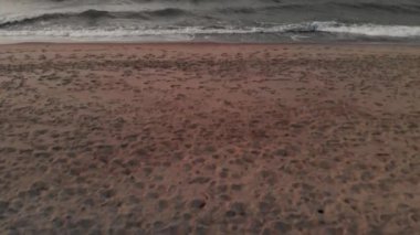 Akşam, sahilin açılış sahnesindeki uçuşun hava görüntüsünü çekti. Sahildeki dalgalardan denize doğru kamerayı kaldırın.