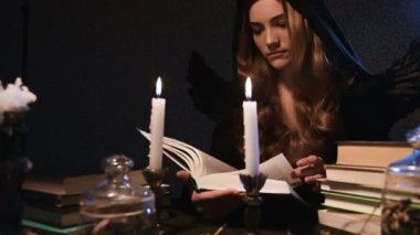 Siyah kapüşonlu, uzun saçlı ve kanatlı çekici bir kadının portresi karanlık bir odada oturur ve mum ışığında sihirli kitaplar okur. Sıkıcı kendini izole etme cadılar bayramı