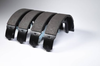 Gri zemin üzerinde davul frenleri için yeni dört fren yastığı seti