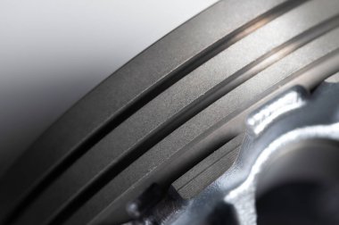 Gri arkaplandaki içten yanmalı motorun yakın çekim pistonu. Motor tamiri için yeni yedek parça. Arkaplanı onar