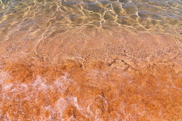 Homok torzult textúrája a víz alatt. Átlátszó vízhullámok, homokhullámok és a napfény fénye. A tengerfenék háttere — Stock Fotó