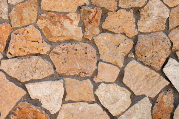 An uneven wall of decorative stacked cobblestones. Medieval background decorative insert — Stock Photo, Image