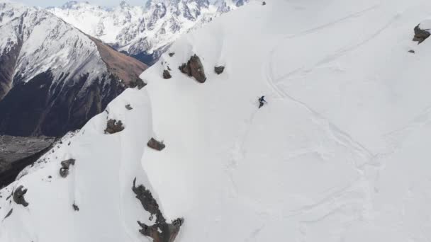 겨울 내내 산을 오르는 장비를 손에 들고 눈덮인 산비탈에서 내려오는 4K 의 사람입니다. 환경 개념 — 비디오