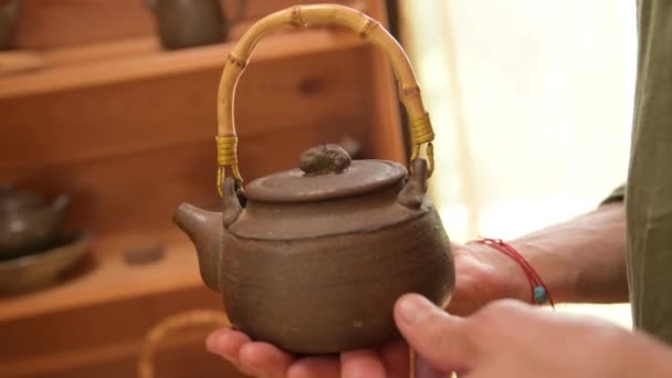 Een mannelijke pottenbakker toont zijn werk Yixing klei theepot voor een handgemaakte theeceremonie in de buurt. Ondiepe scherptediepte — Stockvideo