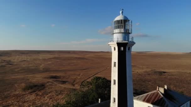 Vista aérea del faro marítimo costero se encuentra en la orilla del mar o el océano. Edificios históricos para fines especiales — Vídeos de Stock