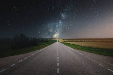 Yazın asfalt yolda, yıldızlı gökyüzü ve Samanyolu ile. Rüyalara giden yol